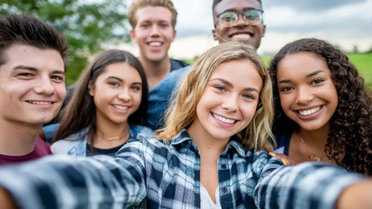 Group of teenagers smiling at the camera. Text reads, researchers have found heavy drinking during adolescence disrupts brain development.