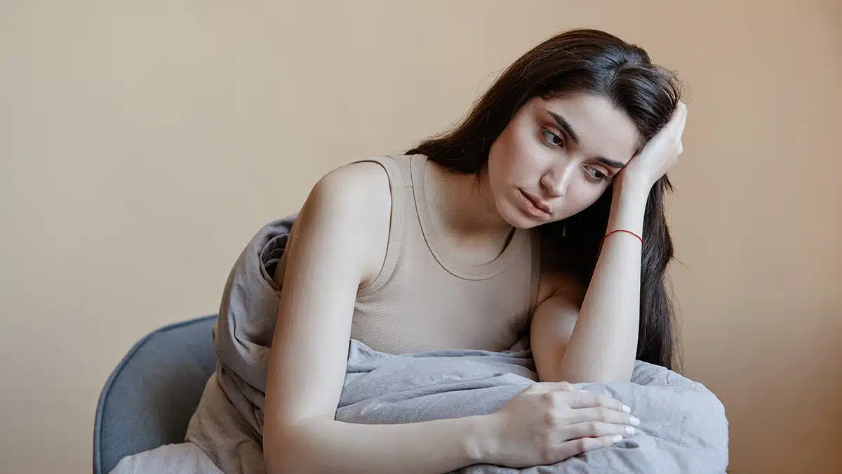 Depressed woman leaning holding her head.