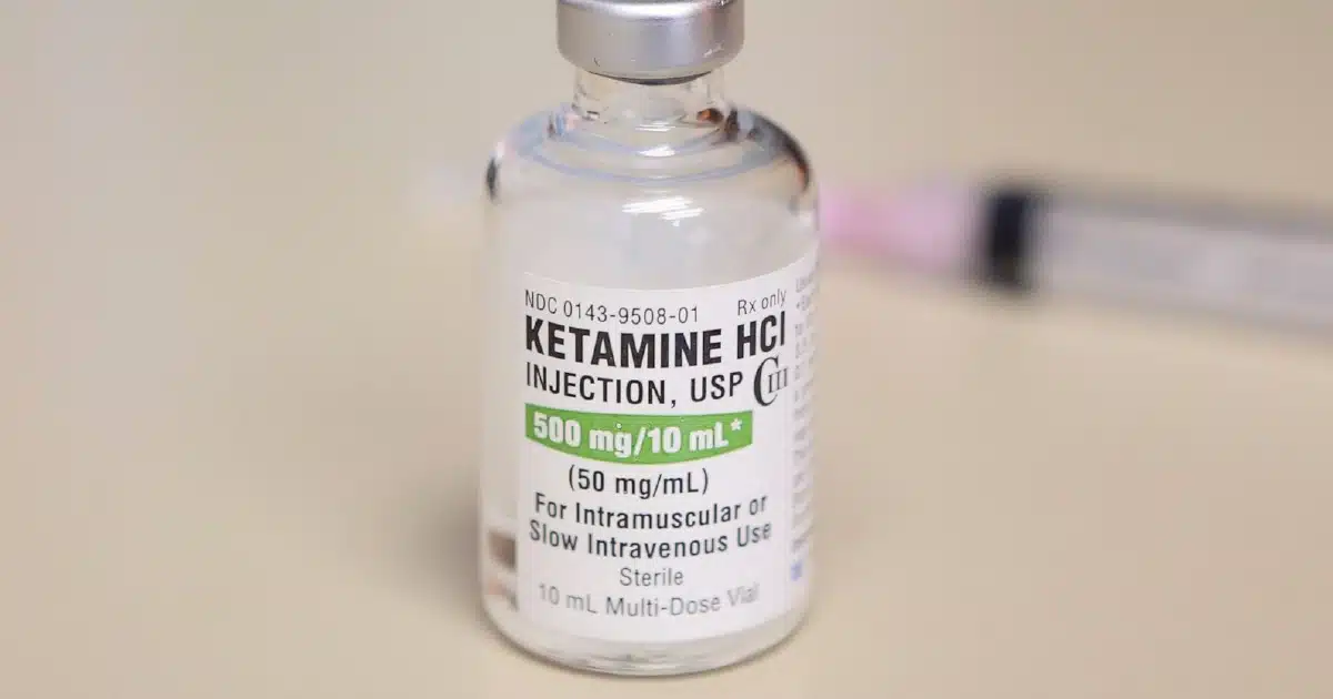 Vial of ketamine on a table.
